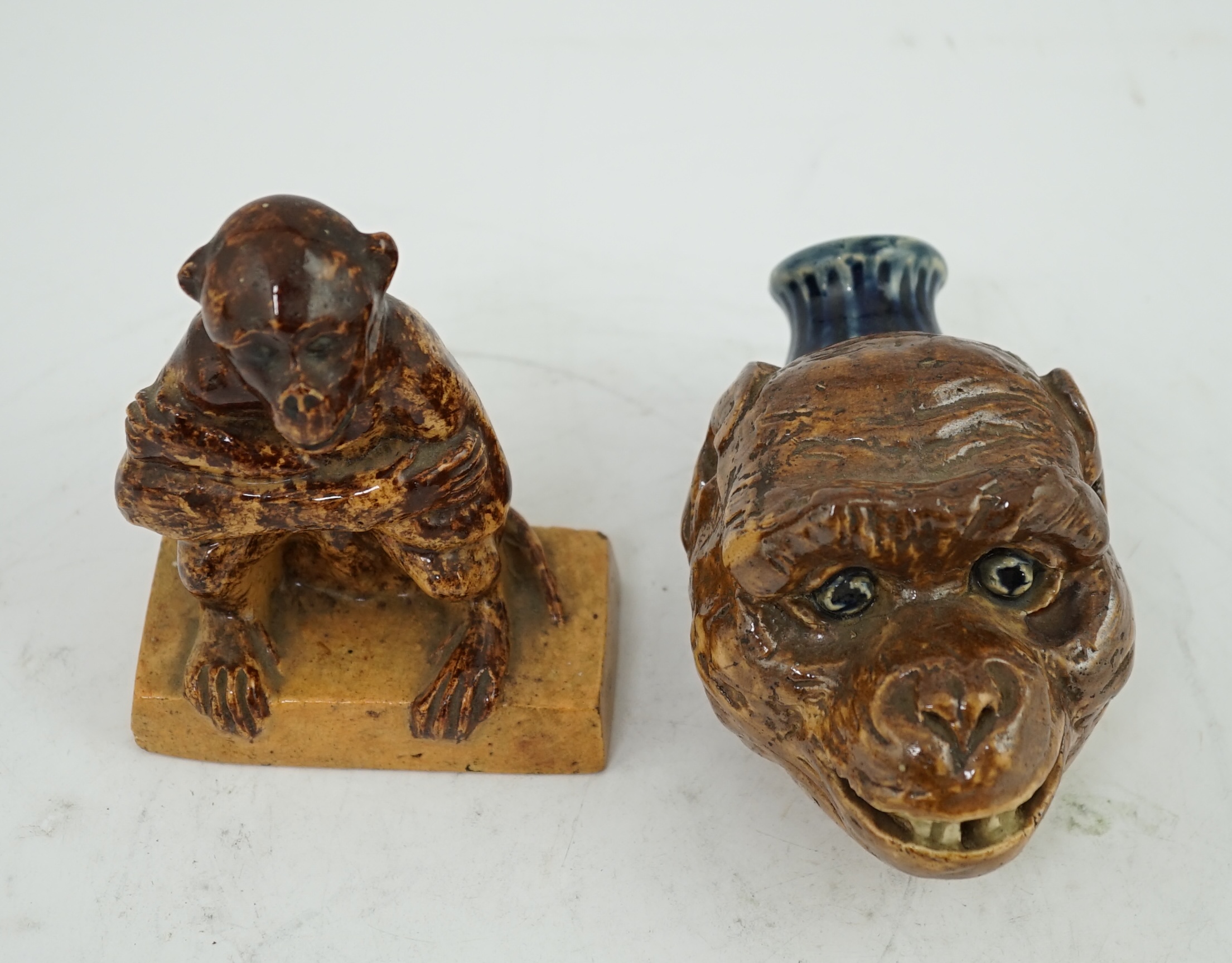 A Clapham Common pottery figure of a seated monkey by J. Frisby Jordan, c.1925, and a stoneware monkey head flask, by JP